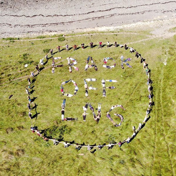 Climate activists spell out "Frack Off LNG" with their bodies during a mass trespass of the site of the proposed Shannon LNG fracked gas import terminal on the Shannon Estuary in north Kerry today, Sunday, 7th August 2022. Over 150 people from around Ireland took part in the two-hour occupation which organisers described as a “show of strength and a warning” to project developer, US corporation New Fortress Energy and the Irish government. The direct action was the culmination of a six-day Climate Camp on nearby farmland. Photograph: Michael Higgins